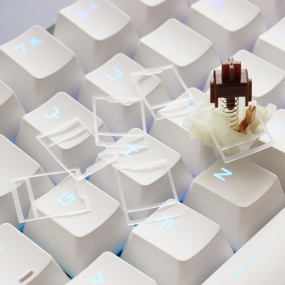 Several HTV 0.18mm switch films resting on white keycaps, one fitted to a brown tactile switch